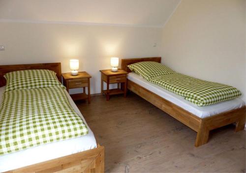 two beds in a room with two lamps on tables at Ferienhaus Fischbachtal in Heimbach