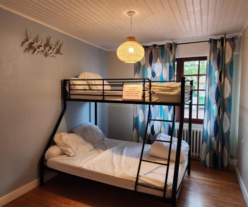 Pokój z łóżkiem piętrowym z 2 łóżkami piętrowymi i żyrandolem w obiekcie LA VILLA MONTA w mieście Vendays-Montalivet