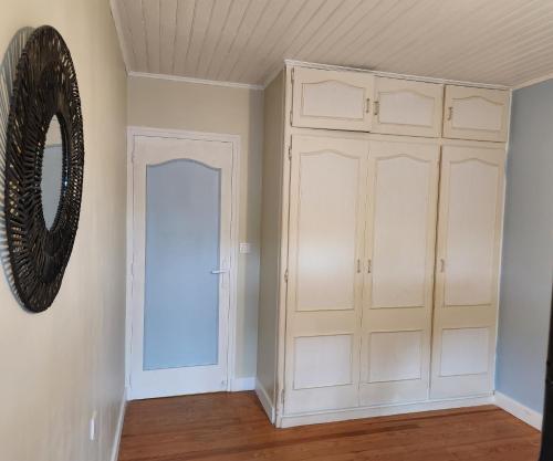 Cette chambre comprend un placard blanc et un miroir. dans l'établissement LA VILLA MONTA, à Vendays-Montalivet