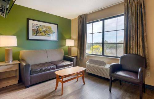 a living room with a couch and a chair and a window at Extended Stay America Suites - Melbourne - Airport in Melbourne