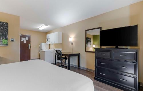 a hotel room with a bed and a flat screen tv at Extended Stay America Suites - Melbourne - Airport in Melbourne