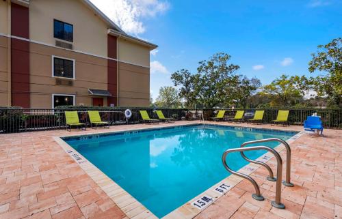 una piscina con sillas y un edificio en Extended Stay America Suites - Melbourne - Airport, en Melbourne