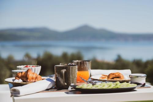 a table with plates of food and orange juice at Vigna Caio Relais & Spa in Bracciano