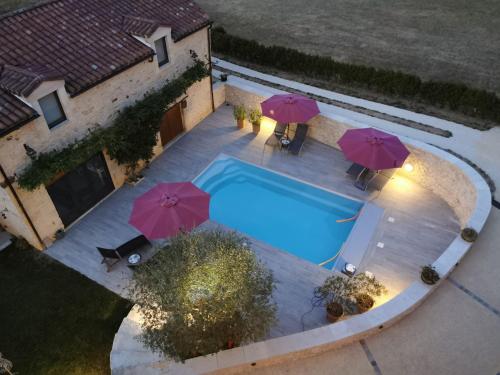 Una vista aérea de una piscina con sombrillas. en Gîte Jacques Brel 5 étoiles, en Les Arques