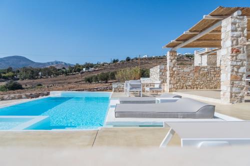 a villa with a swimming pool and a patio at Aegean Feelings in Piso Livadi