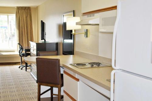 a kitchen with a refrigerator and a table with chairs at Extended Stay America Suites - Orlando - Altamonte Springs in Orlando