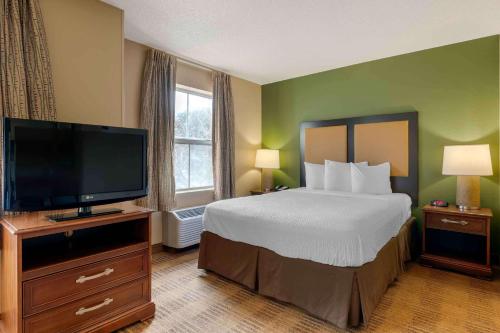 a hotel room with a bed and a flat screen tv at Extended Stay America Suites - Orlando - Convention Center - 6443 Westwood in Orlando