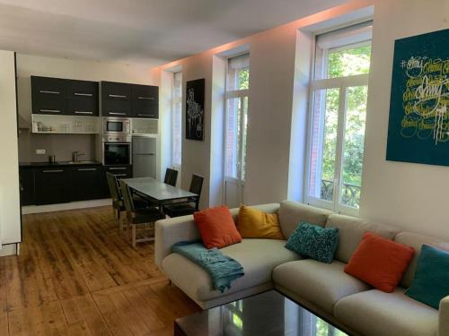 - un salon avec un canapé et des oreillers colorés dans l'établissement L'Élégance du Midi - climatisation réversible, à Toulouse