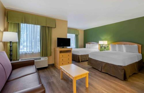 um quarto de hotel com duas camas e um sofá em Extended Stay America Suites - Orlando - Convention Center - Universal Blvd em Orlando