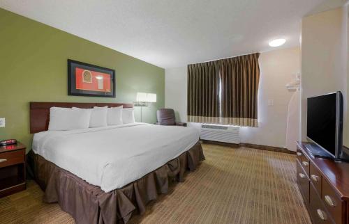 um quarto de hotel com uma cama grande e uma televisão de ecrã plano em Extended Stay America Suites - Orlando - Lake Mary - 1036 Greenwood Blvd em Lake Mary