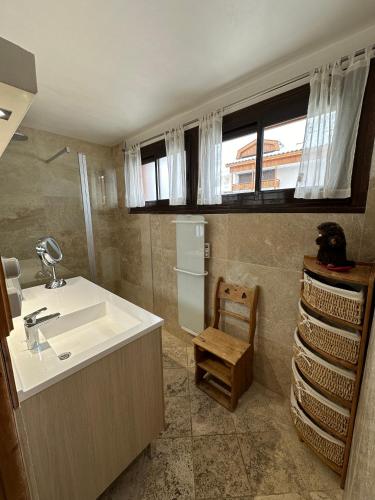 La salle de bains est pourvue d'un lavabo, d'une fenêtre et d'une chaise. dans l'établissement Grand appartement lumineux 53m², 3 pièces, 6 à 8 pers, centre station, pied pistes, à Les Deux Alpes