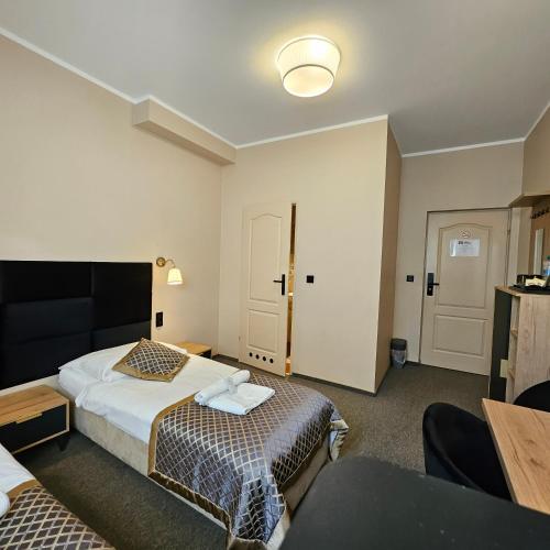 a hotel room with two beds and a table at Willa Kłodzko-Zacisze - sauna, siłownia, komnata solna, parking in Kłodzko