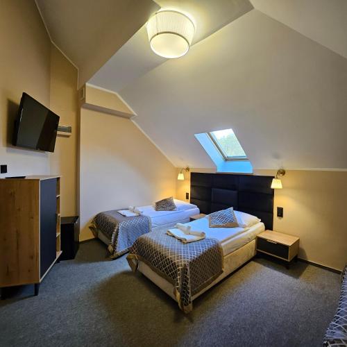 a hotel room with two beds and a skylight at Willa Kłodzko-Zacisze - sauna, siłownia, komnata solna, parking in Kłodzko
