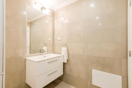 La salle de bains est pourvue d'un lavabo blanc et d'un miroir. dans l'établissement Casa Estrella at Boavista Resort, à Lagos