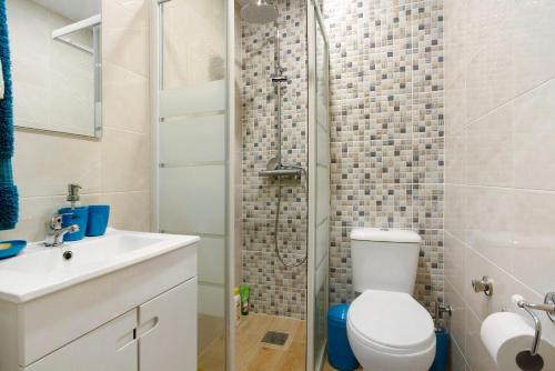 uma casa de banho com um chuveiro, um WC e um lavatório. em Slice of Paradise- Palheiro de Golf em Funchal
