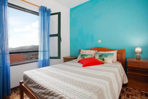 a bedroom with a bed with a large window at Slice of Paradise- Palheiro de Golf in Funchal