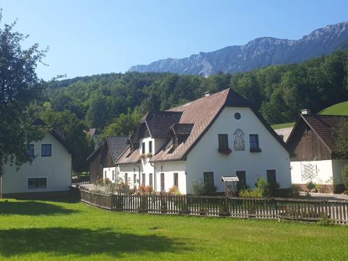 a white house with a fence and mountains in the background at Familie Stoier in Reichenau