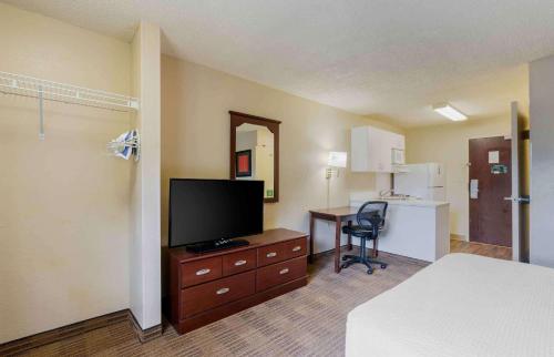 a hotel room with a bed and a television and a desk at Extended Stay America Select Suites - Orlando - Maitland - 1760 Pembrook Dr in Orlando