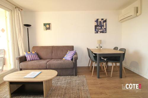 un salon avec un canapé et une table dans l'établissement L'escandiado - 4 couchages, à Sausset-les-Pins