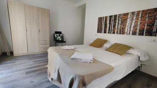 una camera con letto e lenzuola bianche di Boutique 2 apartamento Ave centro Lleida a Lleida