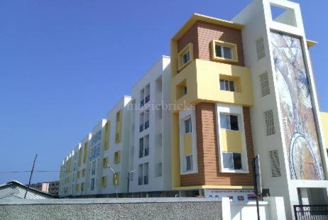 a white and yellow building in front of a building at Rental in Chennai