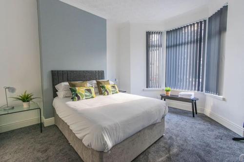 een slaapkamer met een groot bed en 2 ramen bij New Stylish 5BD, 5min from town in Cardiff