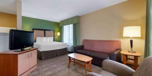 Una habitación de hotel con una cama, un sofá y un televisor. en Extended Stay America Suites - Orlando - Orlando Theme Parks - Vineland Rd, en Orlando