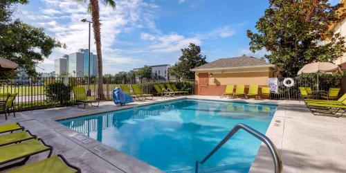 a swimming pool with chairs and a fence at Extended Stay America Suites - Orlando - Orlando Theme Parks - Vineland Rd in Orlando