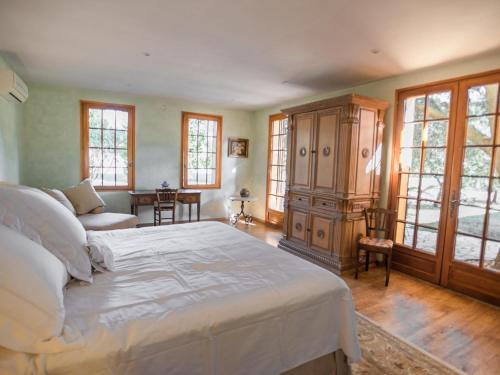 een slaapkamer met een bed, een kast en ramen bij La grande Sorgues in Sorgues