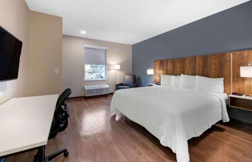 a hotel room with a large bed and a desk at Extended Stay America Premier Suites - Orlando - Sanford in Sanford