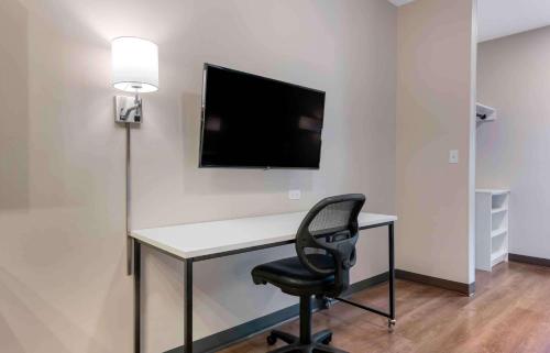 a desk with a chair and a television on a wall at Extended Stay America Premier Suites - Orlando - Sanford in Sanford