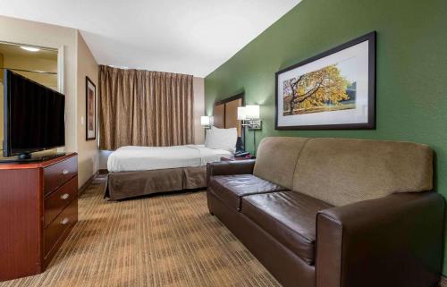 a hotel room with a couch and a bed at Extended Stay America Suites - Orlando - Southpark - Commodity Circle in Orlando