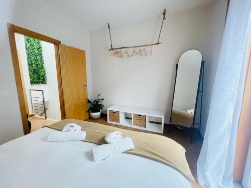 um quarto com uma cama branca e toalhas em Casa Sonia Great location Quiet area Easy access em Óbidos