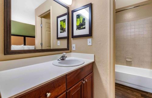 een badkamer met een wastafel, een spiegel en een bad bij Extended Stay America Suites - Orlando - Southpark - Commodity Circle in Orlando