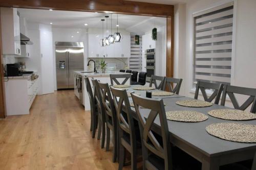 cocina y comedor con mesa y sillas en Where Luxury Retreat meets Convenience!, en Tottenham