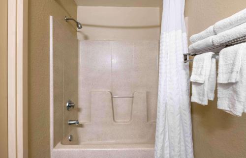 a bathroom with a shower with a white shower curtain at Extended Stay America Suites - Jacksonville - Lenoir Avenue East in Jacksonville