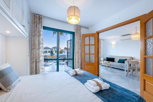 ein Schlafzimmer mit großem Bett und ein Wohnzimmer in der Unterkunft 797 HOLIDAY RENTALS - Apartamento en Pueblo del Parque in Arroyo de la Miel