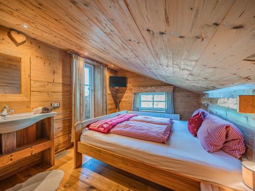 a bedroom with a bed in a wooden cabin at Hilde 1 in Kirchdorf in Tirol