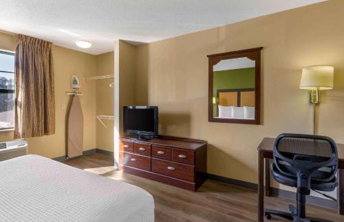 a hotel room with a bed and a desk with a television at Extended Stay America Suites - St Petersburg - Clearwater - Executive Dr in Clearwater