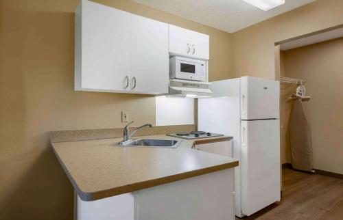 a kitchen with a sink and a white refrigerator at Extended Stay America Suites - St Petersburg - Clearwater - Executive Dr in Clearwater