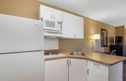 a kitchen with a white refrigerator and a sink at Extended Stay America Suites - St Petersburg - Clearwater - Executive Dr in Clearwater