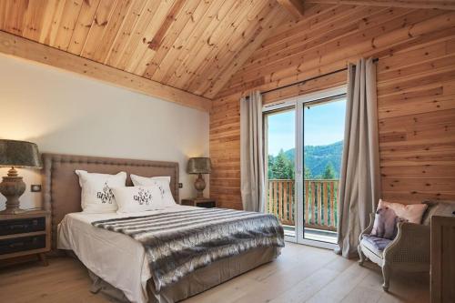 a bedroom with a bed and a large window at FRGK " Luxury Chalet" in Saint-Étienne-de-Tinée