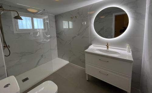a white bathroom with a sink and a mirror at Villa Evelyn in La Florida