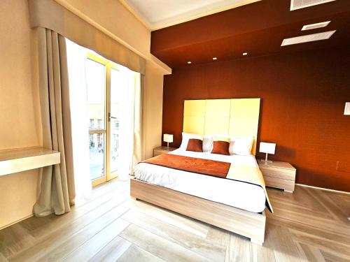 ein Schlafzimmer mit einem Bett und einem großen Fenster in der Unterkunft Trilogy Prestige - Central Premium Suites in Lecce