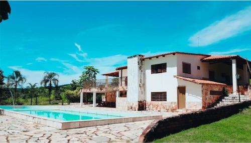une maison avec une piscine en face de celle-ci dans l'établissement Fazenda Araras Pirenópolis, à Pirenópolis
