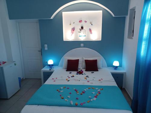 una camera blu con un letto con il cuore sopra di Studios-Apartments-Rooms Evelina Beach Pension a breath away from the Black Beach offer private rooms&studios to suit every traveler's needs a Perissa