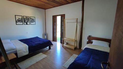 um quarto com duas camas e uma porta para um corredor em Rancho dos Mantas em Santo Antônio do Pinhal