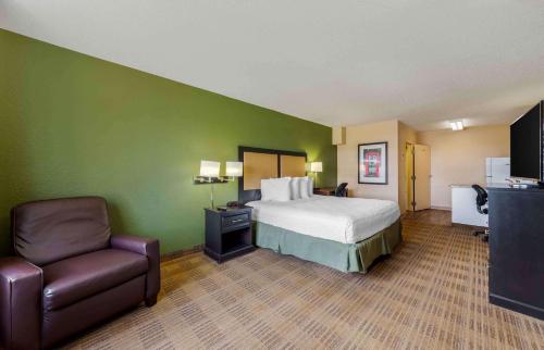 a hotel room with a bed and a chair at Extended Stay America Suites - Fort Lauderdale - Cypress Creek - Andrews Ave in Fort Lauderdale