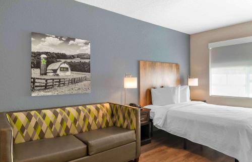 Habitación de hotel con cama y sofá en Extended Stay America Premier Suites - Fort Lauderdale - Cypress Creek - Park North en Pompano Beach