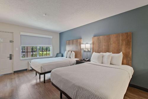 a hotel room with two beds and a window at Extended Stay America Suites - Miami - Airport - Blue Lagoon in Miami